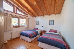 a bedroom with two beds and a window at Cabañas Neyén in Malalcahuello