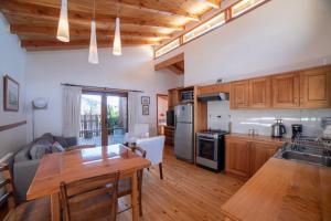 a kitchen and living room with a table and a couch at Cabañas Neyén in Malalcahuello