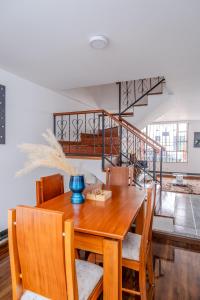 una mesa de comedor con sillas y una escalera en Sauna Sierra House, en Tunja