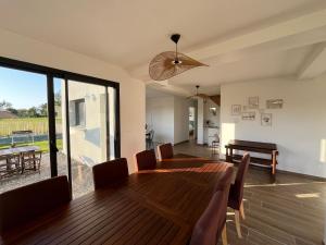 a dining room with a wooden table and chairs at Villa entre Terre et Mer in Hauteville-sur-Mer +11 photos