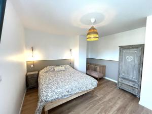 a bedroom with a bed and a dresser and a lamp at Villa entre Terre et Mer in Hauteville-sur-Mer