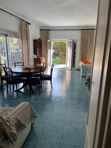 Una sala de estar con una mesa y sillas de madera. en Villa Fiorella, en Fregene