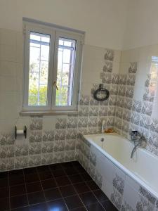 Un baño con bañera y ventana. en Villa Fiorella, en Fregene