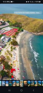 a view of a beach with people and the ocean at Casa Confortável Próximo a Lindas Praias in São Sebastião