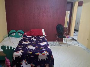 a bedroom with a bed with a comforter with horses on it at Casa Confortável Próximo a Lindas Praias in São Sebastião