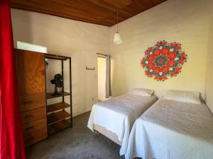 イビコアラにあるSítio Serra da Águiaのベッドが2つあり、壁に時計がある寝室