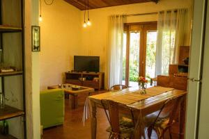 イビコアラにあるSítio Serra da Águiaのテーブルとテレビのあるリビングルーム