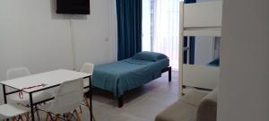 a small room with a bed and a table and chairs at Royal apartment in Lezhë