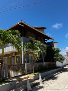 a house with palm trees in front of it at Suítes Cantinho do Ze em Milagres in São Miguel dos Milagres