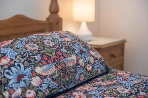 ein Bett mit einer Decke mit Vögeln darauf in der Unterkunft Ivy Cottage in Haverfordwest