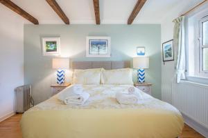 a bedroom with a large bed with towels on it at Willowcot Cottage in Haverfordwest