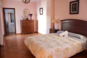 a bedroom with a large bed and a bathroom at Casa La Romana in Aracena