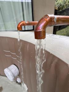 a water faucet with water coming out of it at Refugio Jabuticaba - CASA DA ÁRVORE - Conforto em meio a natureza in Santo Antônio do Pinhal