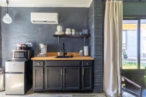 a kitchen with a counter with a sink and a microwave at Casita 4 Cisco Home at The Halles Artisan Venue in Round Top