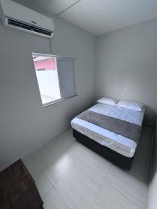 ein weißes Schlafzimmer mit einem Bett und einem Fenster in der Unterkunft Seu espaço em floripa! in Florianópolis + 15 Fotos