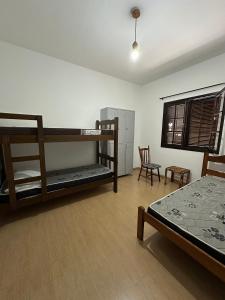 米格尔-佩雷拉Hostel Ares do Mundo的客房设有两张双层床和一张桌子及椅子。 更多16张照片