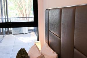 a room with a headboard and a window with a view at StayAU Convenient Apartment with Patio in Box Hill in Box Hill