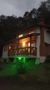 ein großes Haus mit grünem Licht davor in der Unterkunft Chácara Recanto da Mata in Cunha