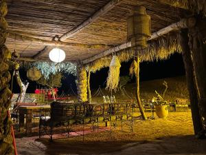 a restaurant with a table and chairs under a roof at Sahara Majestic Luxury Camp in Merzouga