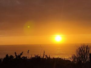 a sunset over the ocean with the sun in the sky at O refuxio do mar in Oia