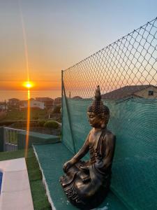 a statue of aitating woman sitting in front of a net at O refuxio do mar in Oia
