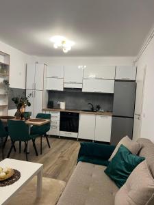Una sala de estar con un sofá y una mesa y una cocina. en Emerald Residence, en Brasov