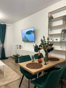 Un comedor con una mesa y sillas verdes. en Emerald Residence, en Brasov