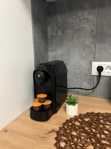 una tostadora negra sobre una mesa de madera en Emerald Residence, en Brasov 32 fotos más