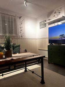 a living room with a tv and a coffee table at Hoda Apartment - Cozy central apartment with free parking in Leknes