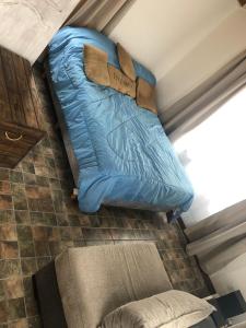 Una cama azul sentada en la esquina de una habitación. en Portofino 43, en Santa Clara del Mar