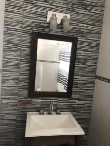 un baño con lavabo y espejo en Portofino 43, en Santa Clara del Mar