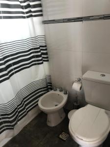 Un baño con inodoro y cortina de ducha en Portofino 43, en Santa Clara del Mar