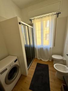 ein Badezimmer mit Waschmaschine und Toilette in der Unterkunft Modern Home near Hospital and City Center in Parma