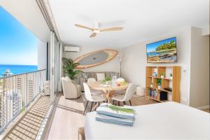 a living room with a table and a balcony at Stylish Studio with Great Ocean Views & Near Beach! in Honolulu