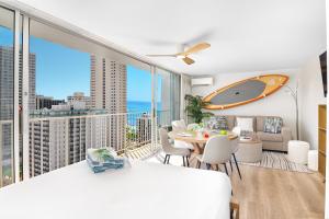 a bedroom with a bed and a table with a surfboard on the wall at Stylish Studio with Great Ocean Views & Near Beach! in Honolulu