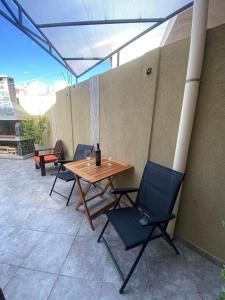 een patio met een houten tafel en stoelen bij Loft Avis in San Luis +4 foto's