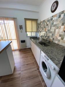 een keuken met een wasmachine en een wastafel bij Loft Avis in San Luis