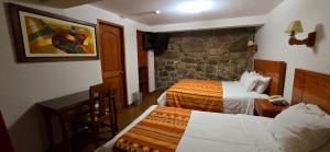 een hotelkamer met twee bedden en een televisie bij Siete Ventanas in Cuzco