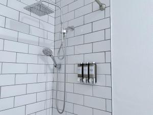 a bathroom with a shower with white tiled walls at Modern Family Haven - Minutes from Disney Magic-OC in Midway City +78 photos