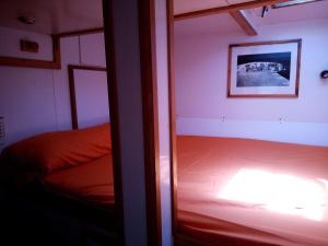 una stanza con una camera da letto con un letto e uno specchio di Comfortable and spacious sailboat a Marigot