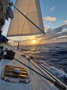 una vela su una barca nell'oceano con un tramonto di Comfortable and spacious sailboat a Marigot