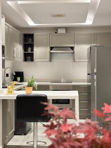 a kitchen with gray cabinets and a white counter top at شقة فاخرة ومميزة في حي الملقا - luxury premium apartment in Al Malaga in Riyadh