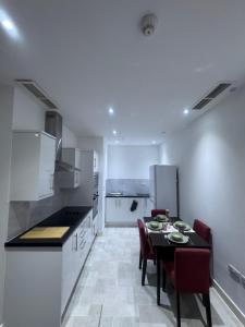ハウンズローにあるSomerville Apartment London Heathrowのテーブルと椅子のあるキッチンとダイニングルーム +20枚の写真