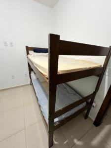una litera de madera en una habitación en Hostel Maravilha, en Palhoça