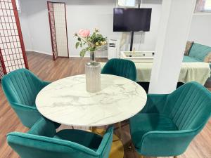 einen Tisch mit Stühlen und eine Vase mit Blumen darauf in der Unterkunft Cozy 1 bedroom close to NYC with private bar in North Bergen + 2 Fotos