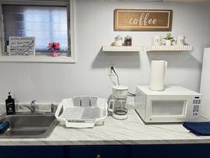 eine Küchentheke mit Mikrowelle und Spüle in der Unterkunft Cozy 1 bedroom close to NYC with private bar in North Bergen