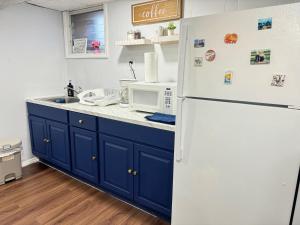 eine Küche mit blauen Schränken und einem weißen Kühlschrank in der Unterkunft Cozy 1 bedroom close to NYC with private bar in North Bergen