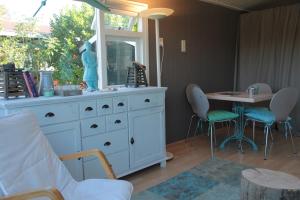 een kamer met een wit dressoir en een tafel met stoelen bij Beachhouse Rockanje in Rockanje