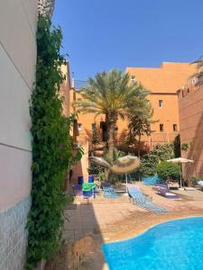 マラケシュにあるRiad Marrakech palmeraieのプール、ヤシの木、椅子が備わるリゾートです。
