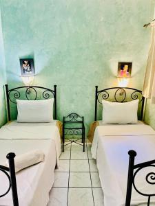 マラケシュにあるRiad Marrakech palmeraieの緑の壁の部屋にベッドが2つある +15枚の写真